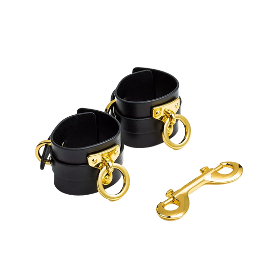 Black cuffs with gold hardware and a matching golden link clasp